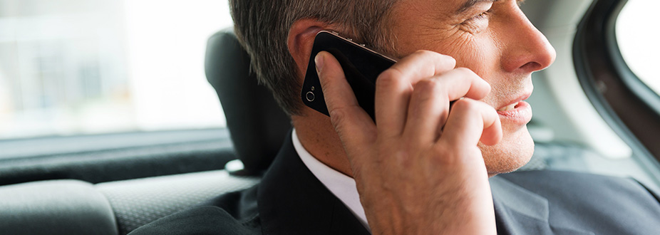 Business Man speaking on the phone in a limosine